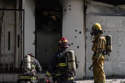 Firefighters extinguish a house that was shot at and burned in Culiacán on November 25.