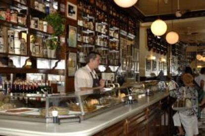 Un camarero atiende a los clientes en la barra de un bar madrileño. EFE/Archivo