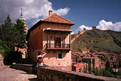 Uno de los accesos a Albarracín, pueblo amurallado de origen árabe. A la izquierda se entrevé el campanario de la catedral del Salvador, del siglo XVI. Al fondo, la muralla y el torreón del castillo del Andador.