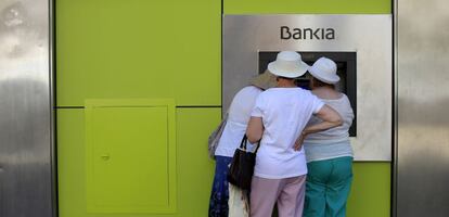 Tres usuarias de un cajero automático de Bankia.