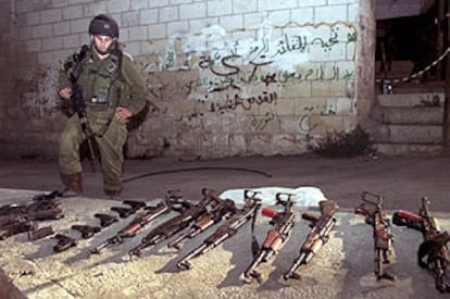 Un soldado israelí, junto a las armas requisadas en Ramala.