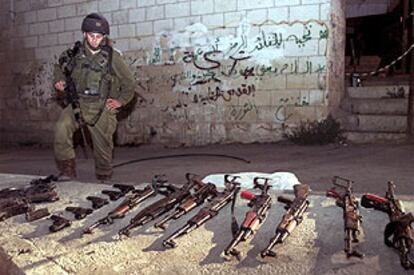 Un soldado israelí, junto a las armas requisadas en Ramala.