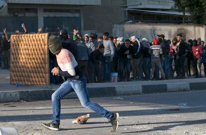 Manifestantes palestinos se protegen de la las tropas israelíes durante las protestas en la puesto de control de Hawara.