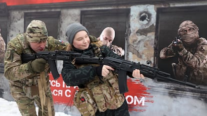 Un oficial ruso enseña a un joven a disparar en Moscú.