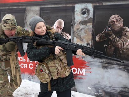 A Russian soldier teaches a youngster how to fire a Kalashnikov during an event on February 24 in Krasnogorsk, a suburb of Moscow.
