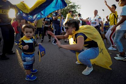 Una madre con su hijo participan en el "banderazo" que celebran los hinchas del Boca Junior previo a su viaje para dispuitar la final de la Copa Libertadores.