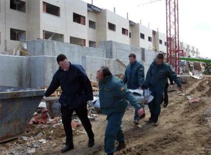 Tres guardias civiles y un empleado de la funeraria trasladan el cadáver del obrero muerto en Arroyomolinos.