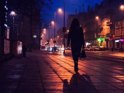 Una mujer camina por una calle, en una foto de archivo.