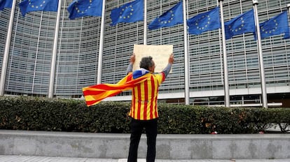 Un independentista con una estelada muestra un cartel frente a la sede de la Comisión Europea en Bruselas.