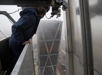 Román Cuadrado, subido a la <i>góndola</i> desde la que limpia los cristales de los edificios Puerta de Europa.