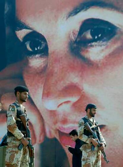 Tropas paramilitares hacen guardia junto a un retrato de Benazir Bhutto cerca de Larkana.