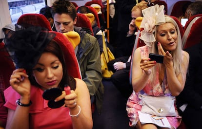 Asistentes a Ascot se dan los últimos retoques en el tren que las lleva al recinto donde se celebran las carreras, en el <i>Día de las Damas</i>.