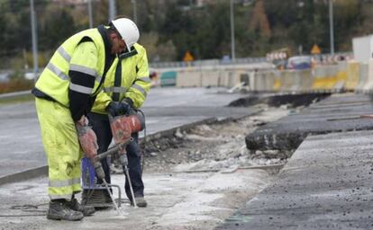 Dos operarios trabajan en en las obras de ampliación de una autovía