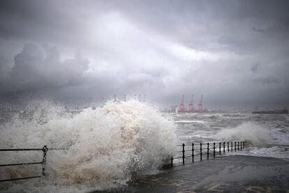 Las olas creadas por los fuertes vientos golpean el malecón del paseo marítimo en Liverpool.