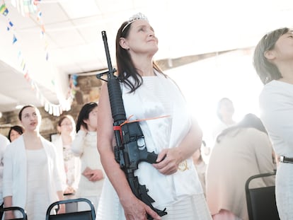 Una mujer sostiene un rifle AR-15 en 2018 en un santuario en Newfoundland (Pennsylvania) de la iglesia de la Unificación, que cree que el AR-15 simboliza la "barra de hierro" en el libro bíblico del Apocalipsis.