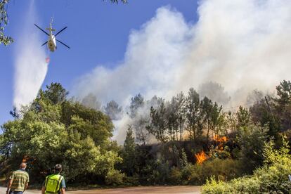 Las llamas y el humo negro y espeso fueron tragándose el monte y llegaron a 200 metros de sus casas. El fuego declarado ayer en el municipio pontevedrés de Soutomaior se embraveció en cuestión de minutos y reservó lo peor para cuando alcanzó el ayuntamiento vecino de Redondela, trepando aprisa, empujado por el viento, hasta los lugares de Ventosela y Reboreda, donde tuvieron que ser desalojadas varias viviendas, entre ellas las de Aldeas Infantiles. En la imagen, un helicóptero intenta sofocar el incendio forestal de Soutomaior (Pontevedra), el 10 de agosto.