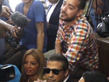 Os presos Mohamed Fahmy (centro) e Baher Mohamed (de pé, acima) falam com a imprensa ao lado da advogada Amal Clooney (direita) e da mulher de Fahmy.