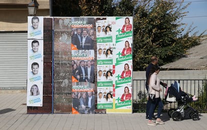 Una pareja con el carrito del bebé mira los carteles electorales de las andaluzas del 2-D en Las Gabias (Granada), el 16 de noviembre de 2018.