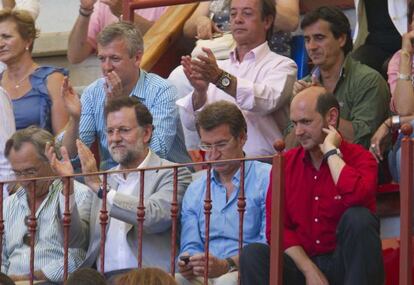 Rajoy, Feij&oacute;o y Louz&aacute;n (con camisa roja), durante una tarde de toros en Pontevedra en 2011.