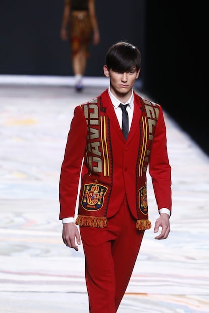 David Delfín con la Selección. El diseñador viste de rojo a uno de sus modelos y borda su nombre en la bufanda de la Roja. El desfile ha sido un intento simbólico de transferir el fervor y el orgullo que existe en España por el deporte nacional al mundo de la moda. 