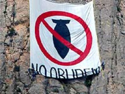 Integrantes de la Plataforma per la Pau despliegan una pancarta contra la guerra ayer en Montserrat.