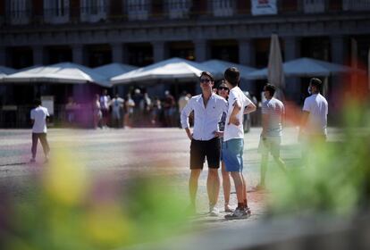 Varias personas pasean con y sin mascarilla, por la Plaza Mayor de Madrid. 