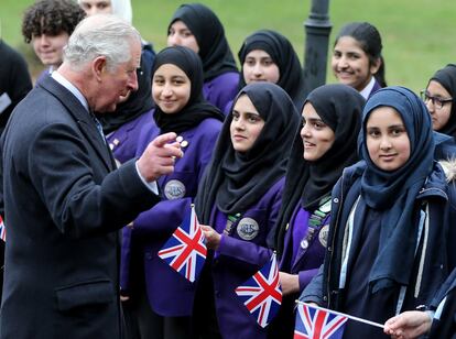 El Príncipe de Gales saluda a las niñas de una escuela local durante una visita al Centro de Herencia Musulmana Británica, en Manchester, donde se ha reunido con miembros de la comunidad musulmana.