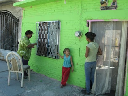 La familia Orozco pinta la fachada de su casa en el Cerro de la Pila, en Durango.