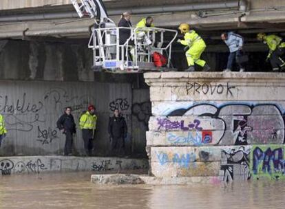 Los bomberos de Málaga, en el momento en el que rescataban ayer a los dos indigentes del puente de Tetuán tras la crecida del río Guadalmedina.
Un vecino intenta salvar animales de su corral en Valderrubio.