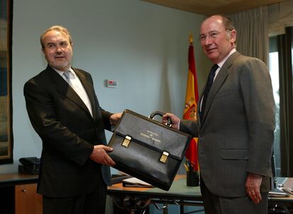 Pedro Solbes, con su antecesor en el cargo, Rodrigo Rato, durante el acto de traspaso de la cartera ministerial, el 18 de abril de 2004.