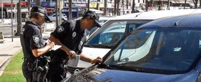 Dos agentes de la Policía Local de Palma de Mallorca sancionando a un vehículo.