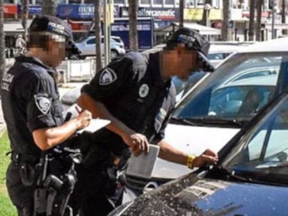 Dos agentes de la Policía Local de Palma de Mallorca sancionando a un vehículo.