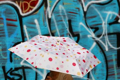 Una mujer camina bajo el sol por el barrio de Queens en Nueva York.