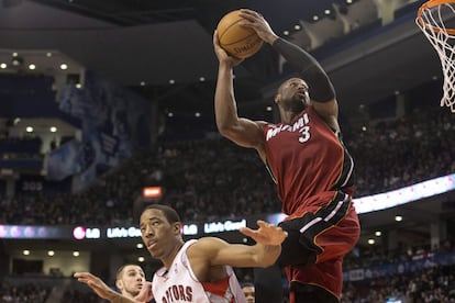 Dwayne Wade se dispone a machacar ante DeMar DeRozan, de Toronto. Los Heats se impusieron a domicilio (91-108).