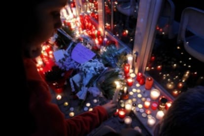 Varias personas depositan flores y velas a las puertas del Instituto Joan Fuster.