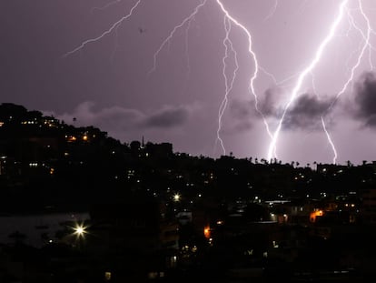 -FOTODELDIA- MEX056.ACAPULCO (MÉXICO), 27/08/2018.- Vista general hoy, lunes 27 de agosto de 2018, de una tormenta eléctrica que ilumina el cielo en el puerto de Acapulco (México). La Onda Tropical Número 32, que cruzará el centro y el sur de México, la aproximación de una nueva onda tropical hacia la Península de Yucatán, áreas de inestabilidad atmosférica superior que cubrirán gran parte del país informo la Comisión Nacional del Agua (Conagua), en un comunicado. EFE/David Guzmán