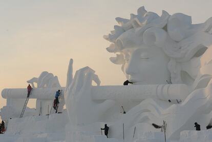 Trabajadores esculpen una de las figuras del Festival de Hielo y Nieve de Herbín en China, el 5 de enero de 2018.