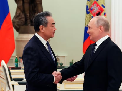 El presidente ruso, Vladímir Putin, y el jefe de Exteriores chino, Wang Yi, estrechan las manos en su encuentro en Moscú este miércoles