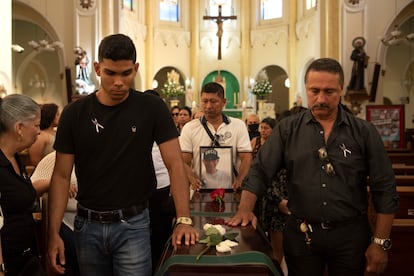 Juan Carlos Llano lleva una foto de su hijo en compañía del hermano Juan David y otros familiares y allegados que asisten a las honras fúnebres de Esteban Llano Marulanda.