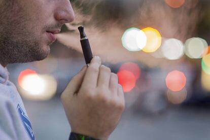 Un hombre fuma un cigarrillo electr&oacute;nico.