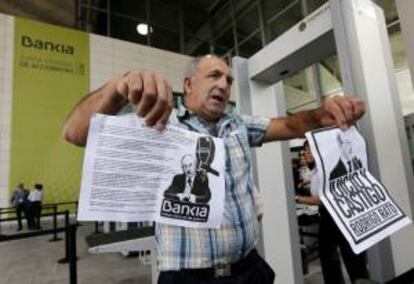 Un afectado por las preferentes de Bankia protesta ante la puerta del Palacio de Congresos de valencia durante la Junta General de accionistas.