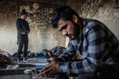 Día Gil rezando junto a Musaver en una de las habitaciones ocupadas en una nave industrial a las afueras de Bihac. Huyeron de Afganistán por temor a ser reclutados por el ejército o lo talibanes. Ellos mismos han escritos sus sueños y emociones en las paredes.