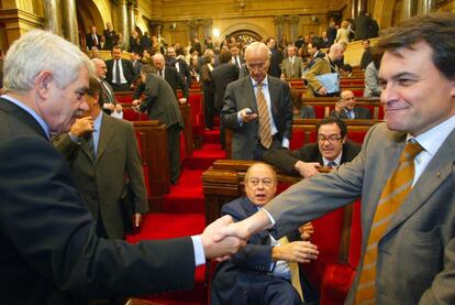 Pasqual Maragall i Artur Mas se saluden, en presència de Jordi Pujol, abans del discurs d'investidura de Maragall al Parlament de Catalunya, el 15 de desembre del 2003.