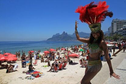 Una integrante de la escuela de samba Mocidade Independente de Padre Miguel posa tras grabar un vídeo para televisión en la playa del Arpoador, en Ipanema, en Río de Janeiro.