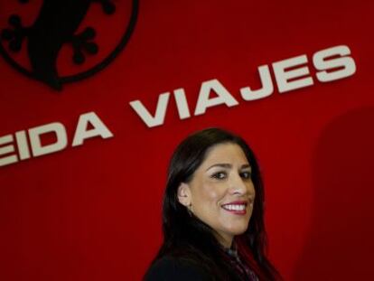 La empresaria Inmaculada Almeida frente a un letrero de su agencia de viajes en Málaga.