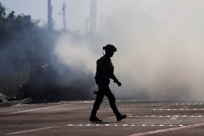 Un soldado camina cerca de un vehículo en llamas, en Mazatlán. Habitantes de otras ciudades, como Los Mochis o Guasave, la primera a 220 kilómetros de Culiacán y la segunda a 160 kilómetros, han reportado cortes y tiroteos también en sus municipios.