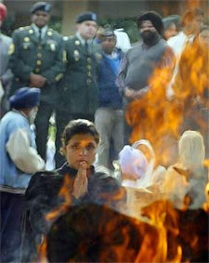 Una familiar de Uday Singh llora frente a la pira funeraria.