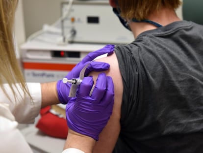 Uma mulheres recebe a vacina da Pfizer contra covid-19.