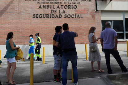 Varias personas hacen cola ante el Centro de Especialidades de Orcasitas para someterse a una prueba PCR en el madrileño distrito de Usera.