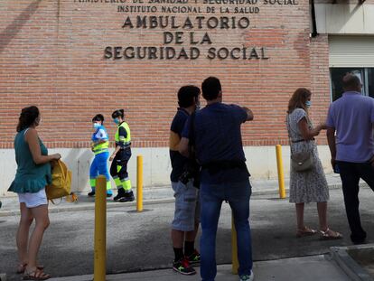 Varias personas hacen cola ante el Centro de Especialidades de Orcasitas para someterse a una prueba PCR en el madrileño distrito de Usera.